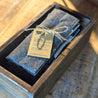 A Sarita bamboo flatware set is tied closed with jute twine and rests in an old farmhouse style box