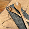 Closeup of a Sarita bamboo for and spoon resting on its jute and cotton pouch