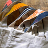 Several Parker bags lie in a row showing a range of colors from the upcycled sari handle linings.